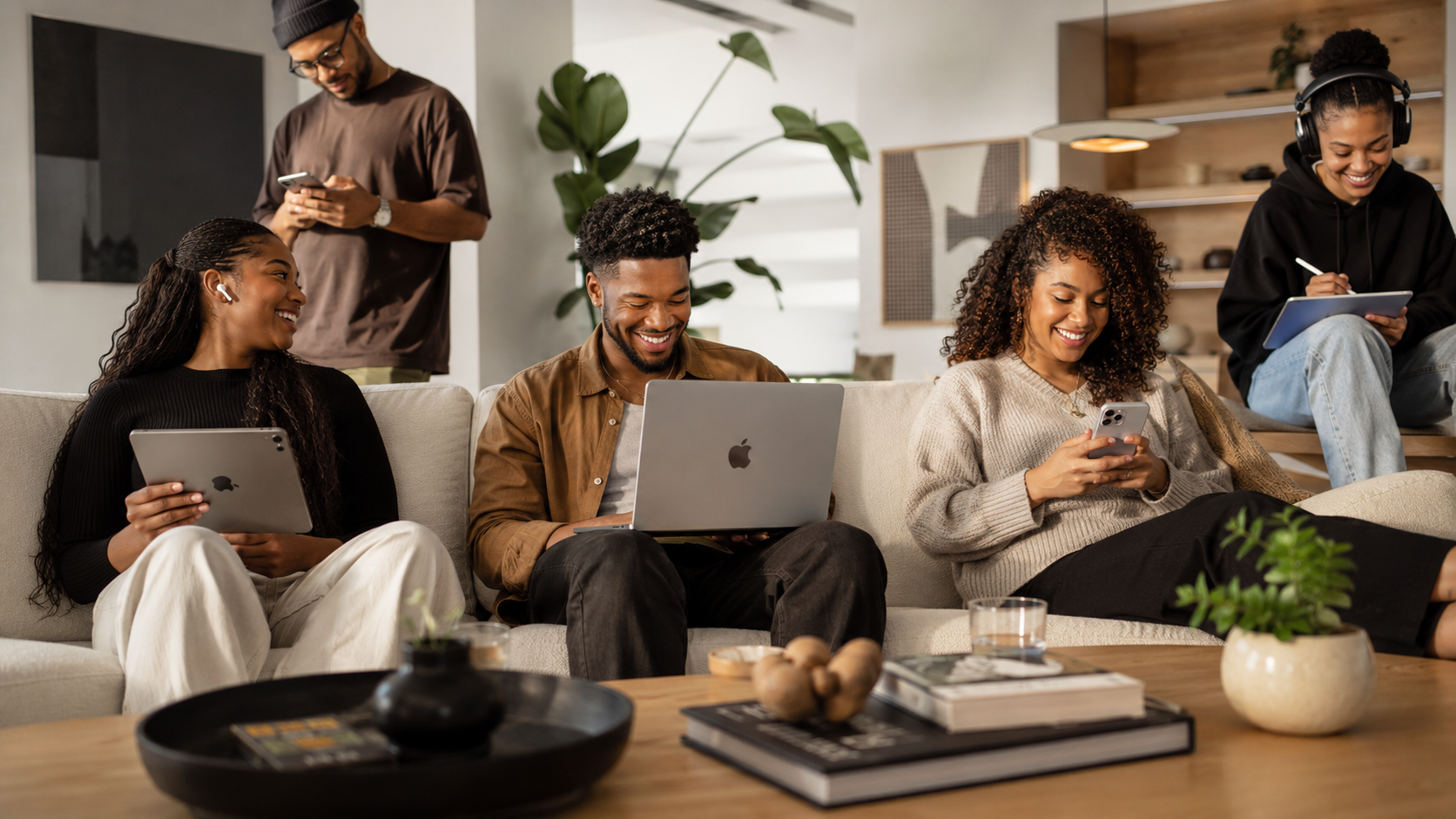 Grupo de jovens a desfrutar de uma experiência com MacBook, iPhone, iPad, AirPods e Apple Watch