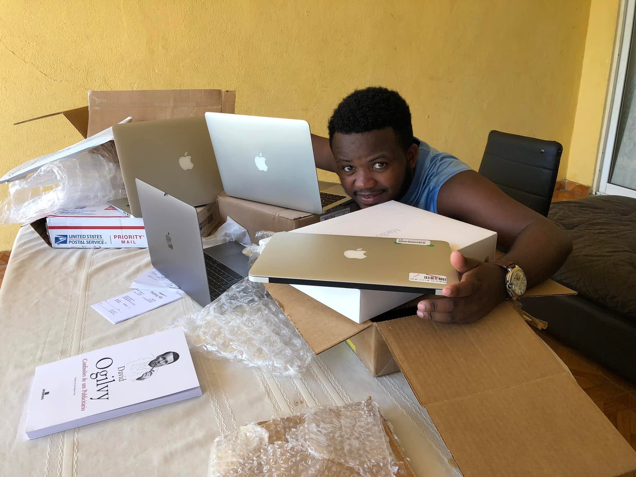 Edmelson com vários MacBooks e caixas de envio